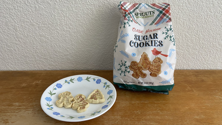 Sprouts holiday sugar cookie bag beside three plated cookies