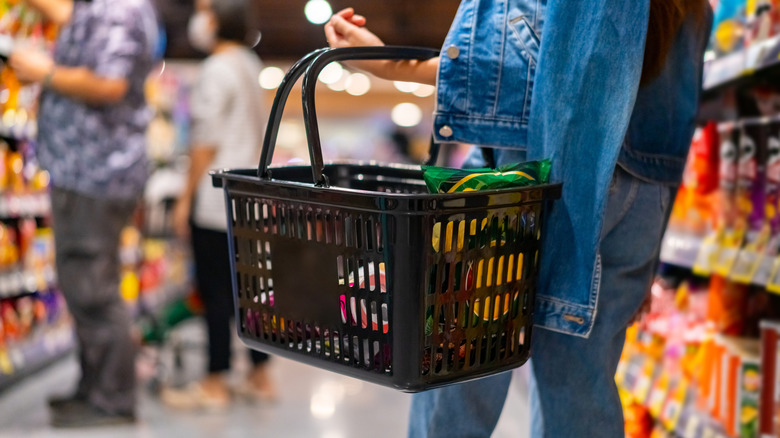 Person shopping at grocery store with basket