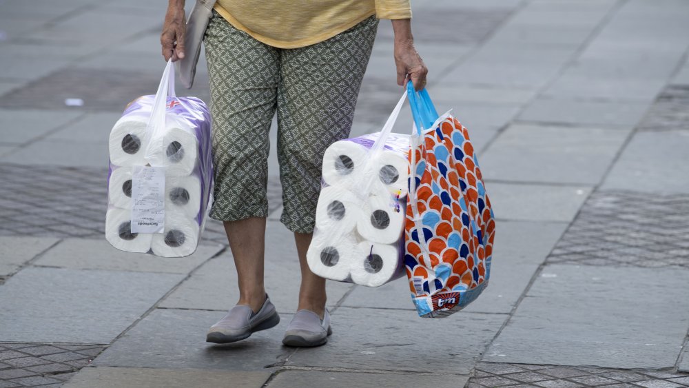 Person shopping with large amounts of toilet paper