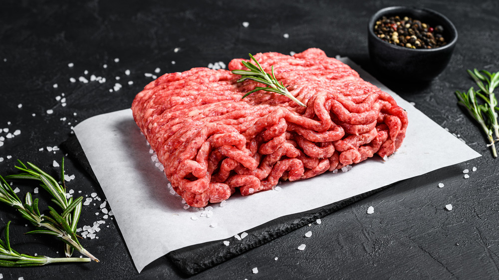 Ground beef on butcher paper with a rosemary sprig