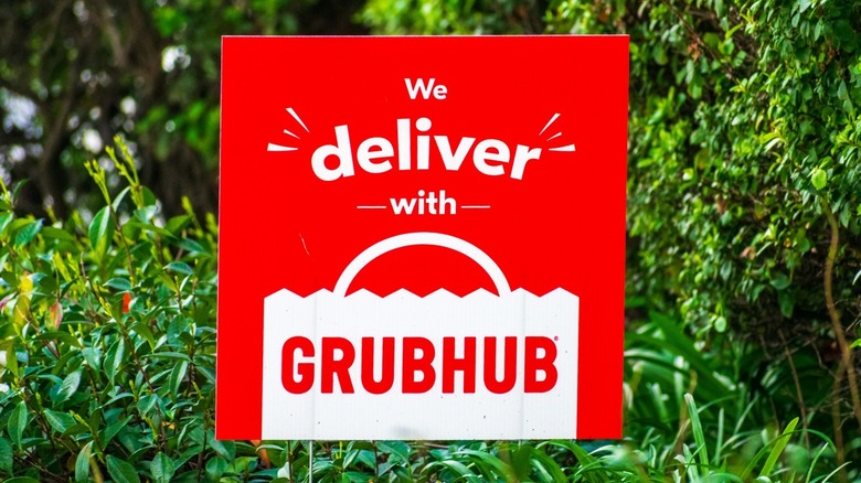 GrubHub sign on background of green plants