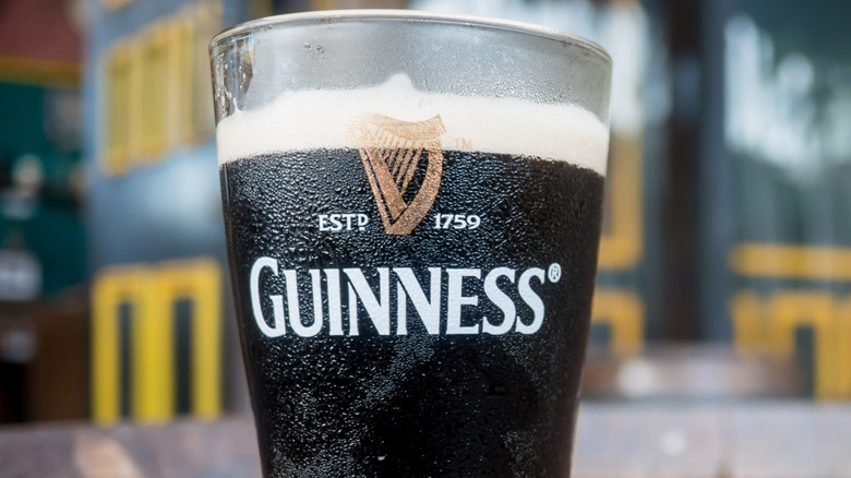 A pint of Guinness on an outdoor tabletop, freshly poured.