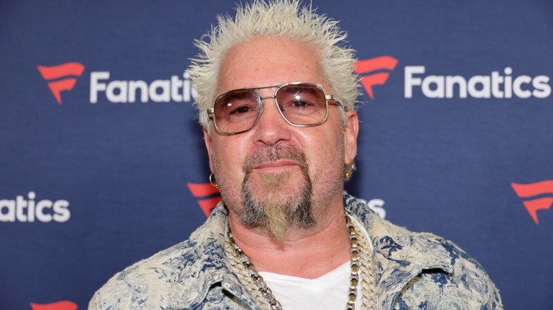 Guy Fieri smiling at a red carpet event