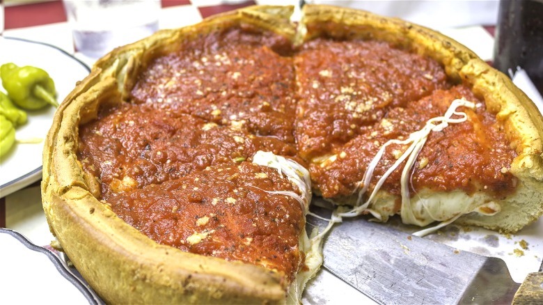 Chicago-style deep-dish pizza on restaurant table.