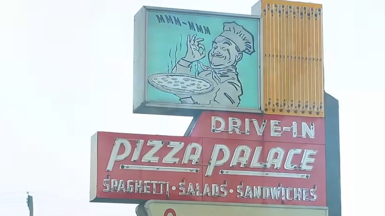 Original Pizza Palace sign against overcast sky