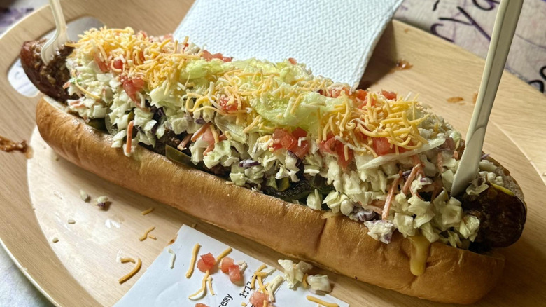 Large hot dog with cheese sauce, jalapeños, lettuce, tomato, cheese