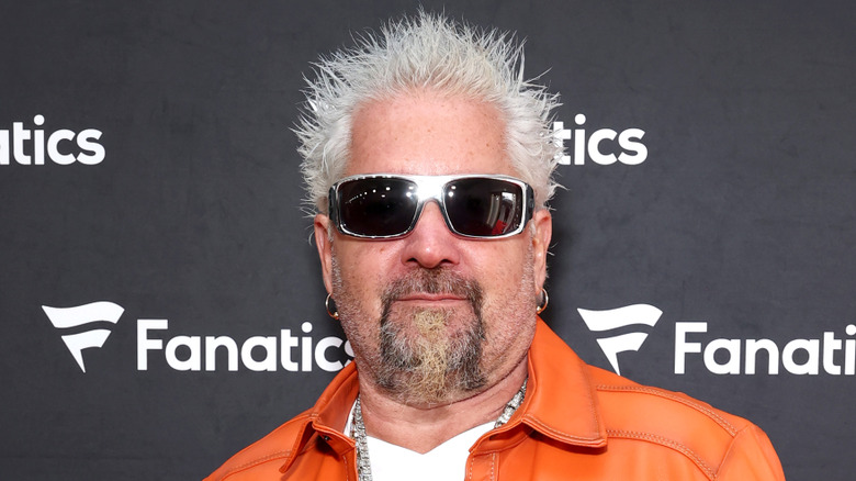 Guy Fieri in sunglasses and orange jacket
