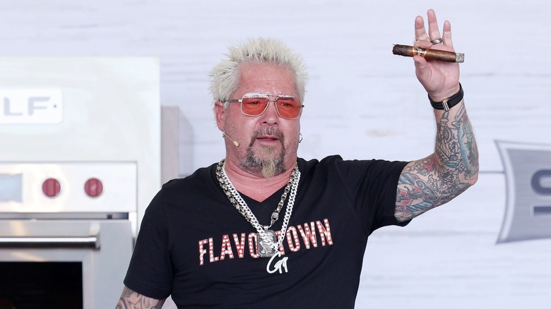 Guy Fieri in Flavortown shirt with cigar