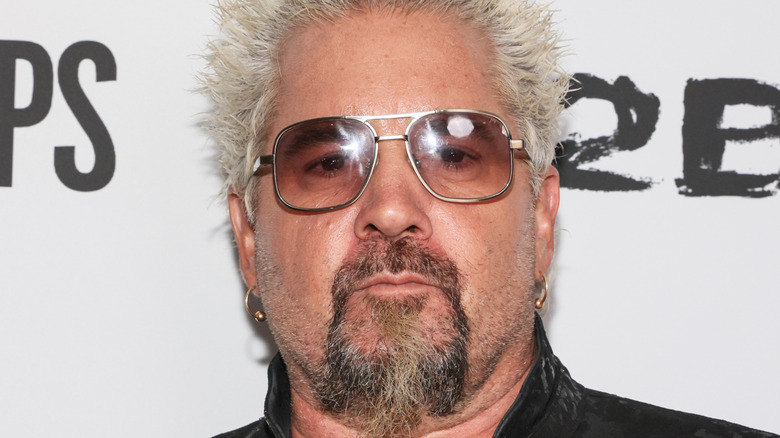 Guy Fieri posing for cameras at publicity event