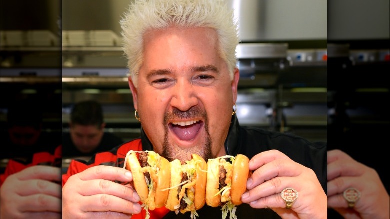 Guy Fieri holds cheeseburgers