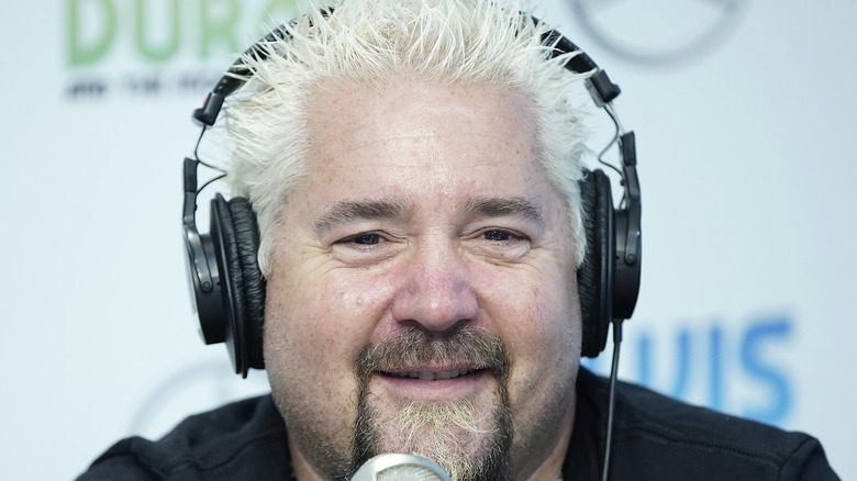 Guy Fieri wearing headphones in front of microphone