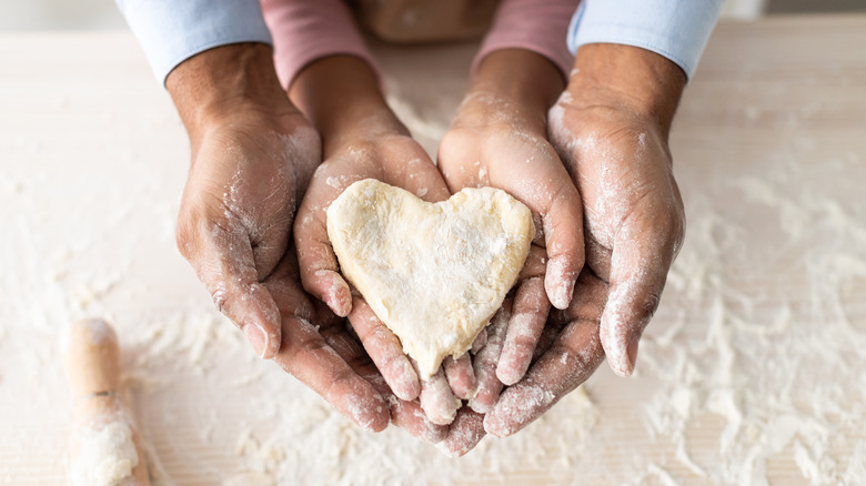 hands with dough and flour and rolling pin