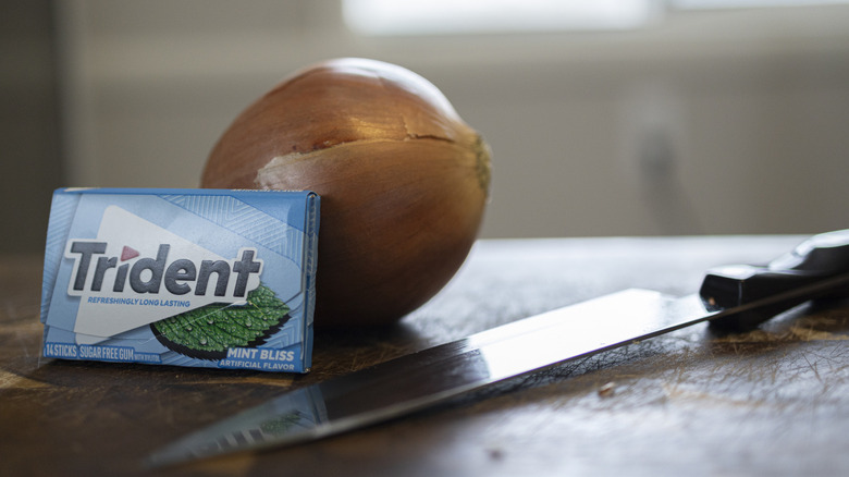 Onion and Trident mint gum and knife on cutting board