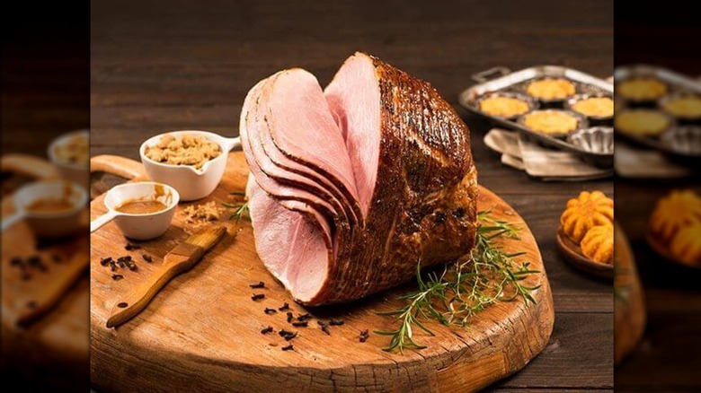 Boneless sliced ham on a wooden cutting board