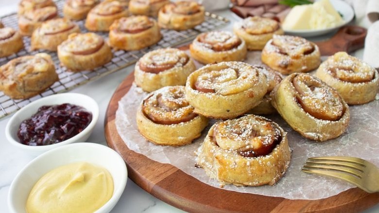 Monte Cristo pinwheels on serving board next to bowls of jam and mustard