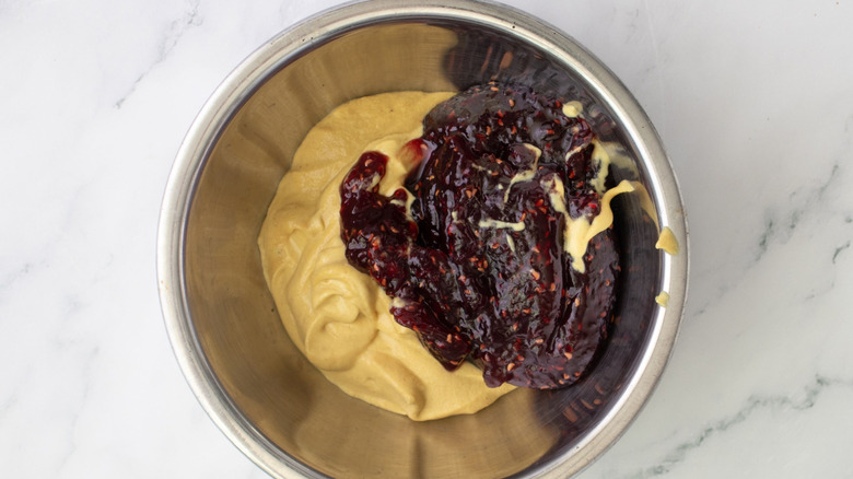 Dijon mustard and raspberry jam in mixing bowl