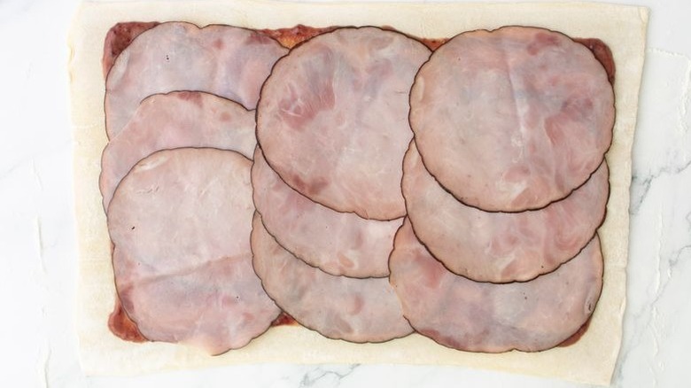 Puff pastry sheet layered with jam and ham slices