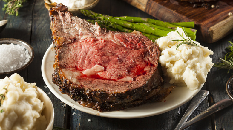 Prime rib on a plate with mashed potatoes and asparagus
