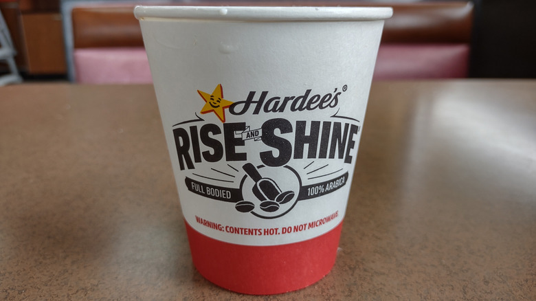 A paper cup of Hardee's coffee that reads 