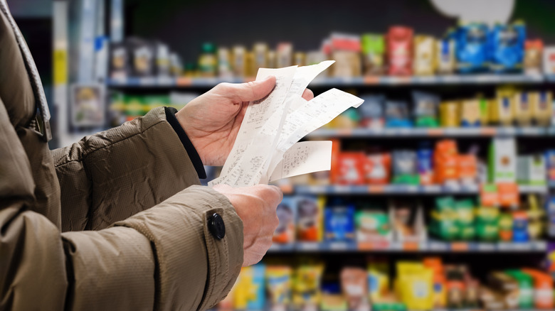 Customer holding grocery receipts