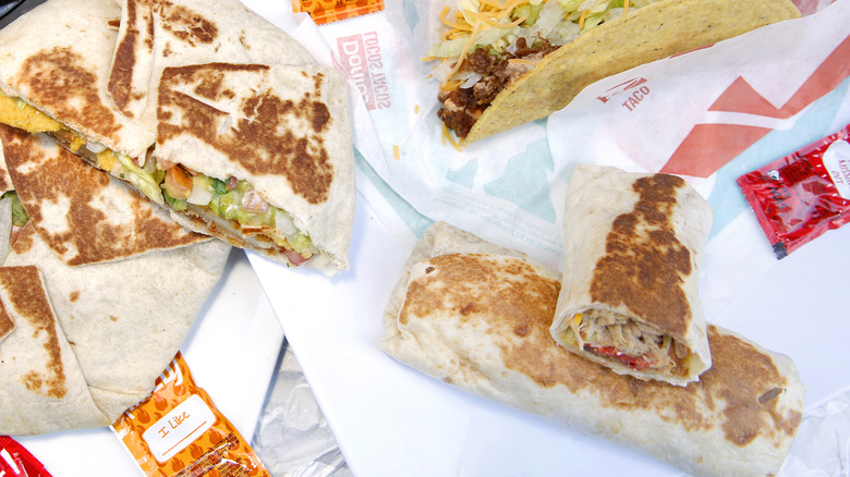 A Taco Bell meal showing a burrito, taco, and crunch wrap supreme
