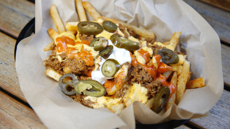 Taco Bell Loaded Steak and Jalapeño fries served in a black plastic bowl lined with a baking sheet
