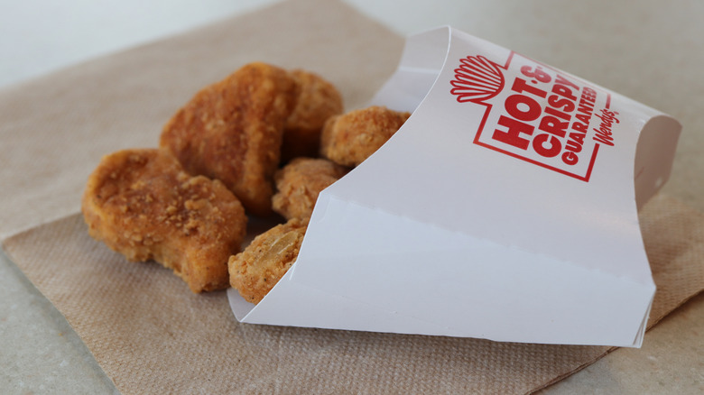 Chicken nuggets spilling from a Wendy's container
