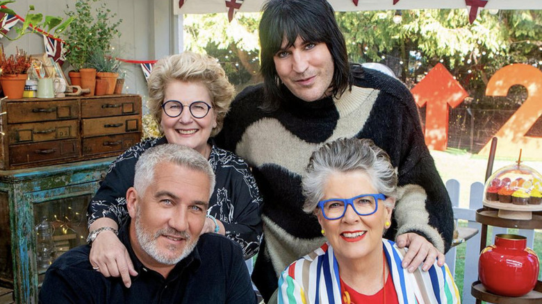 Hosts of Great British Bake Off pose inside tent