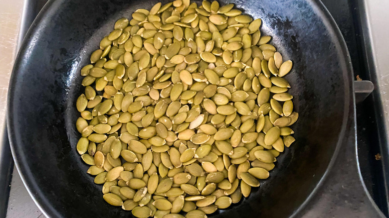 raw pumpkin seeds in pan