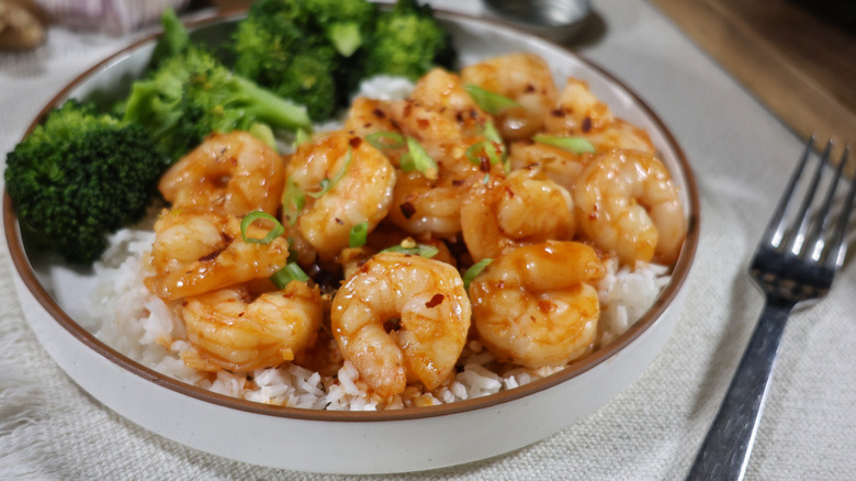 plate of shrimp with spicy honey garlic sauce over rice with steamed broccoli