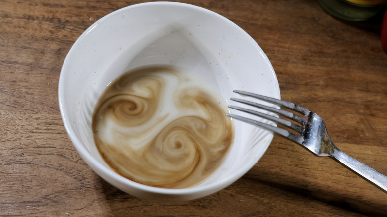 bowl of swirling white and brown liquid with fork resting on the rim