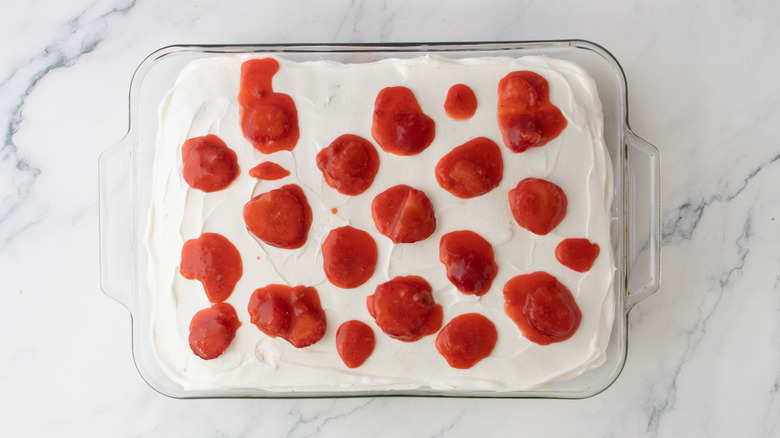 Cake topped with strawberry filling in baking dish