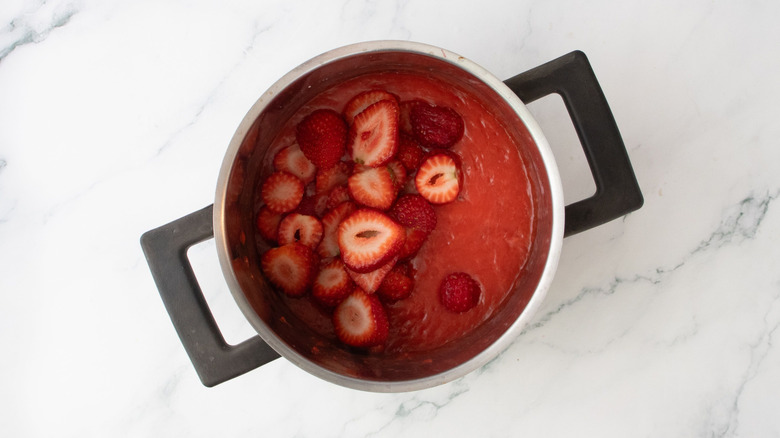 Strawberry puree and sliced strawberries in pot
