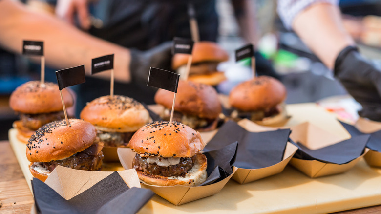 Burgers with black flag toothpicks stuck in them