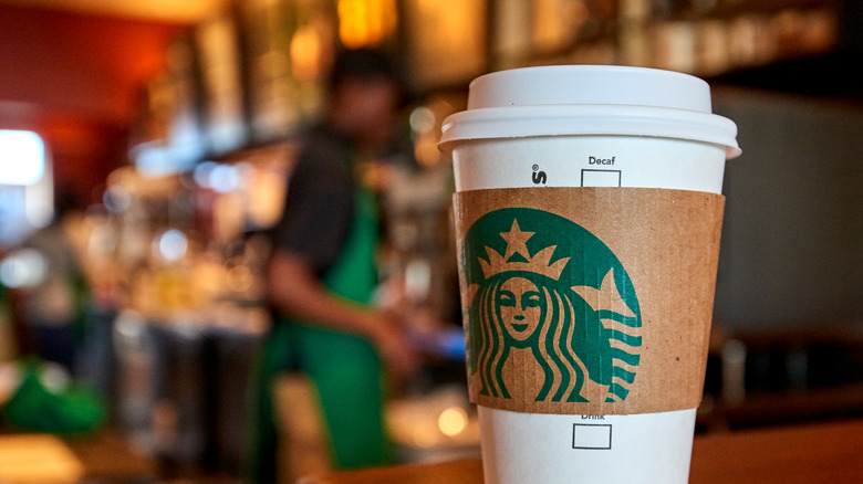 White to-go cup with Starbucks logo sleeve. 