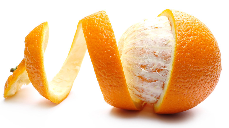 Raw orange surrounded by curled peel