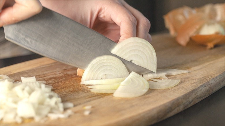 Person chopping white onions