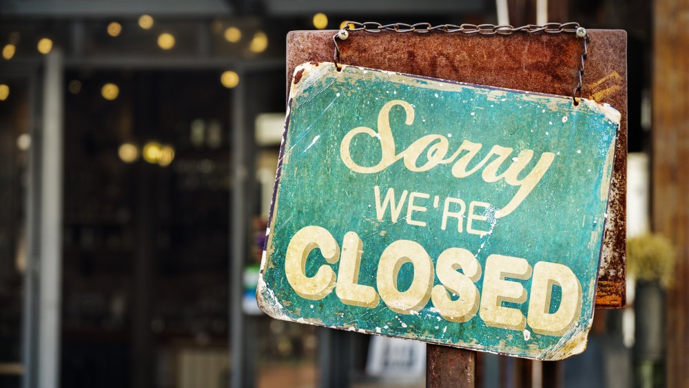 Closed sign in front of shuttered restaurant 