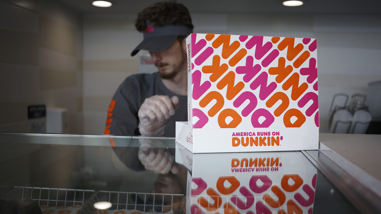 Employee filling open Dunkin' box