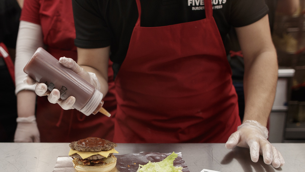 Five Guys employee making a burger