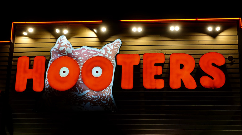 Outside a Hooters restaurant with logo and sign