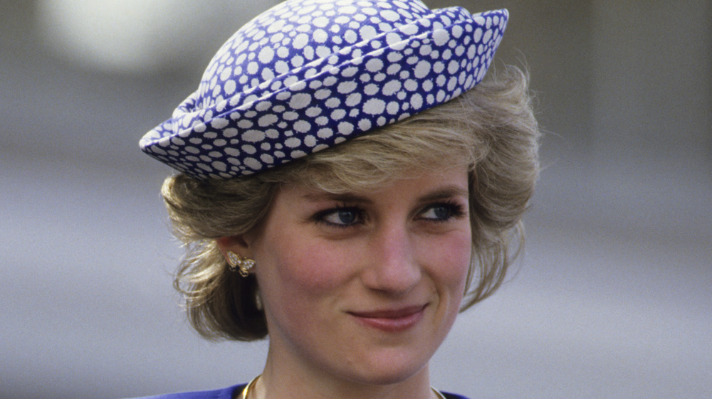 Princess Diana smirking in blue hat