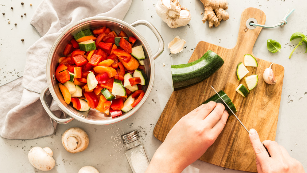 Chef hands cutting from above with stew