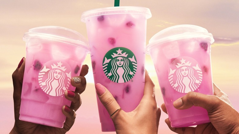 Hands holding pink Starbucks drinks