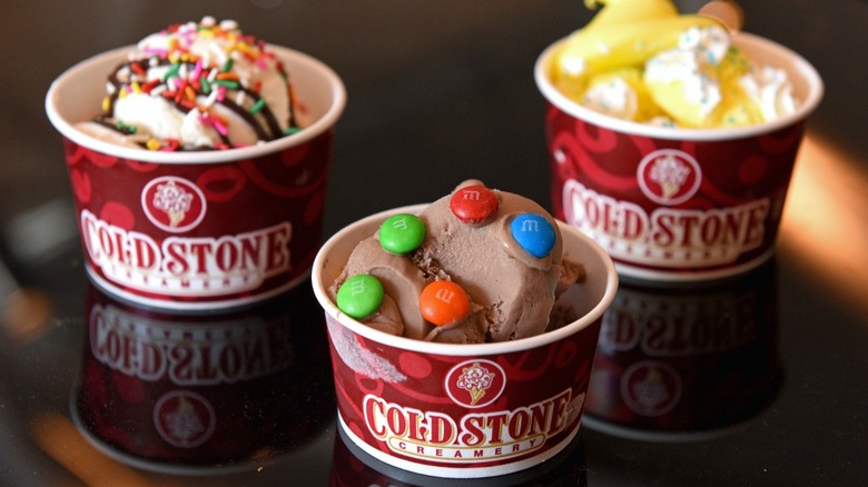 three cups of Cold Stone ice cream with various toppings