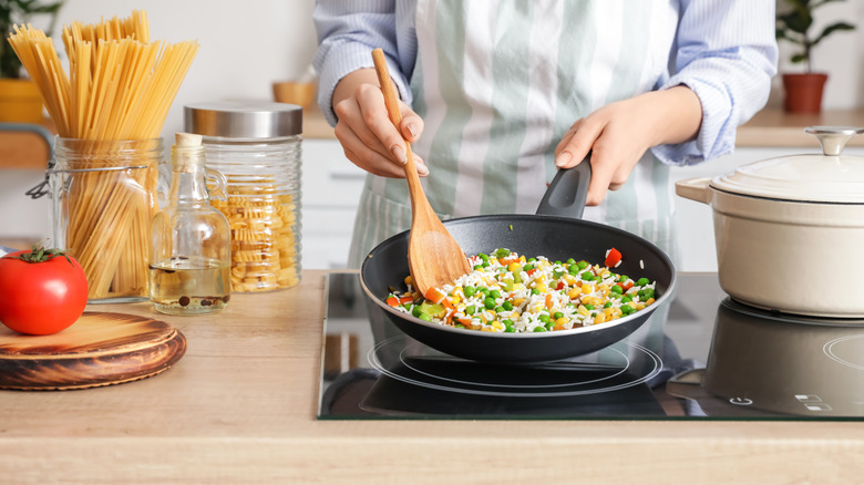 Cooking fried rice in a wok on a stovetop