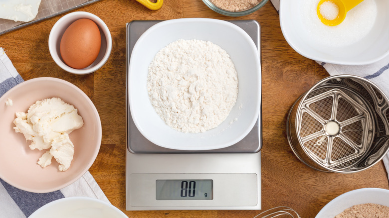 Flour on a digital kitchen scale surrounded by baking ingredients