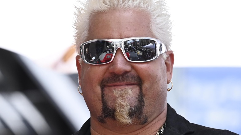 Guy Fieri smiling and wearing sunglasses