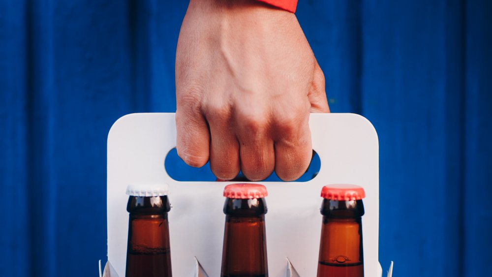 man delivering six pack of beer