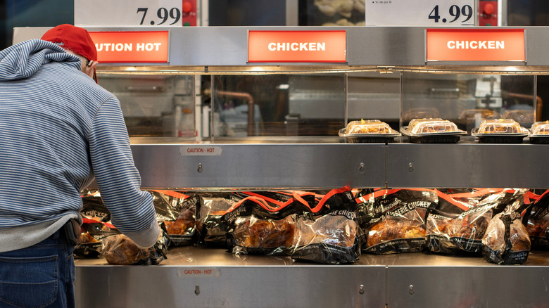 Customer looking at rotisserie chickens